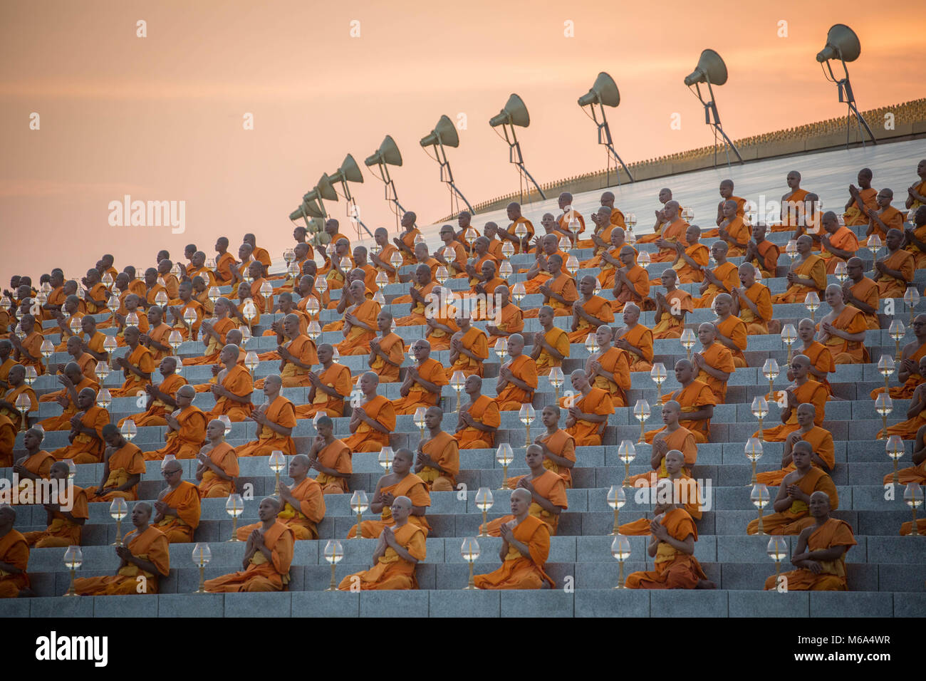 March 1, 2018 - Bangkok, Pathum Thani, Thailand - Monks seen praying while holding lanterns during the yearly Makha Bucha ceremony in the north of Bangkok. More than a thousand monks and hundred of thousand devotees were gathering at Dhammakaya Temple in Bangkok to attend the lighting ceremony. (Credit Image: © Geem Drake/SOPA Images via ZUMA Wire) Stock Photo