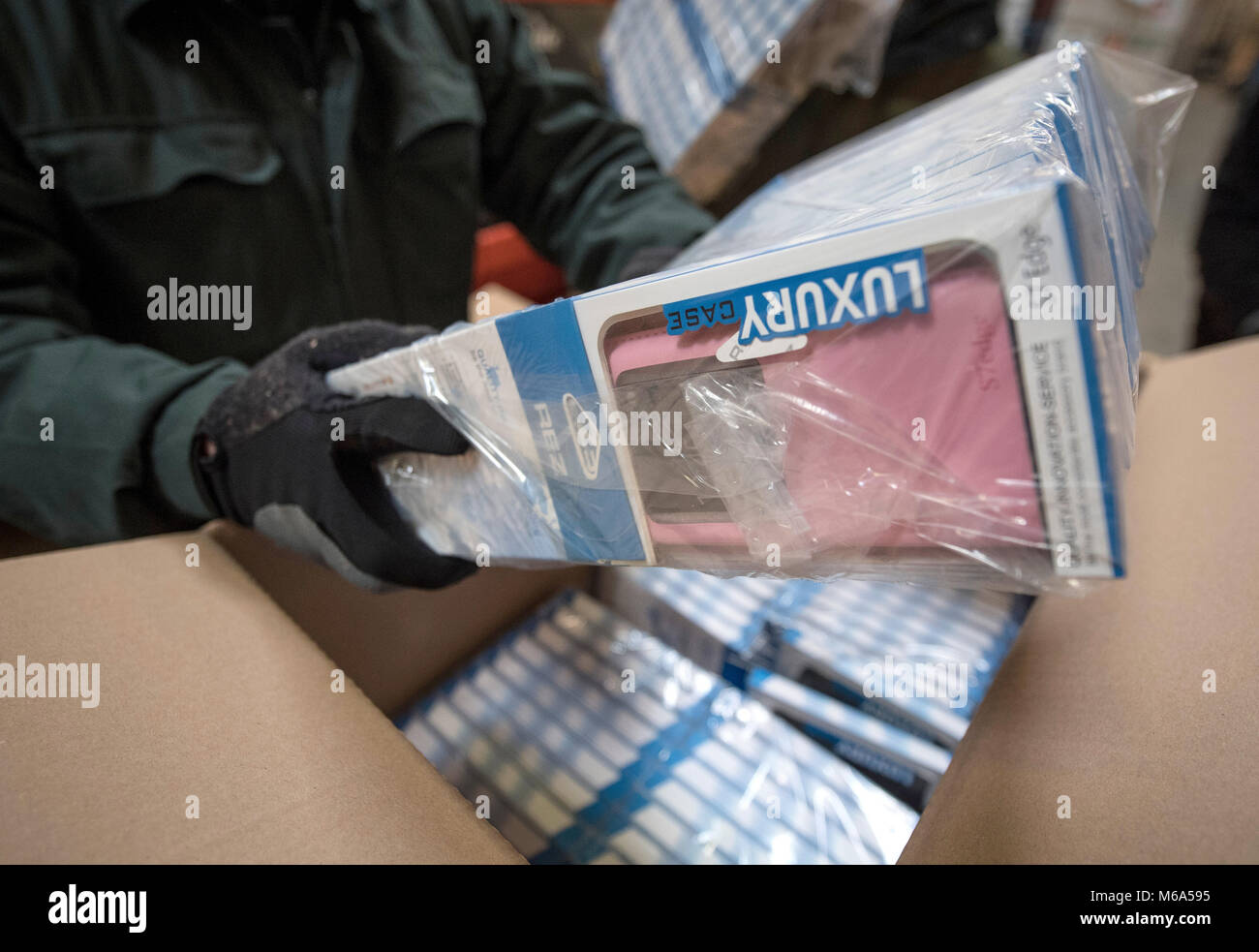 28 February 2018, Germany, Frankfurt: German customs seized fake mobile phone cases at a secret shipping's storage at an industrial estate. In the course of police investigations customs investigators stumbled upon a company that imported huge amounts of phone cases, chargers, batteries, MP3 players and headphones of China's two leading brand manufacturers. Photo: Boris Roessler/dpa Stock Photo