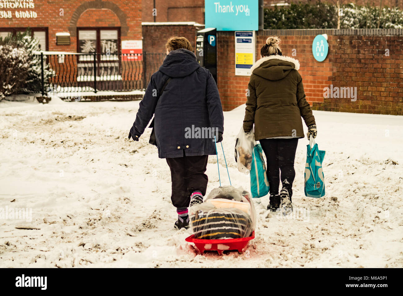 Leominster. 2nd Mar, 2018. UK Weather Shoppers use a toboggan to carry