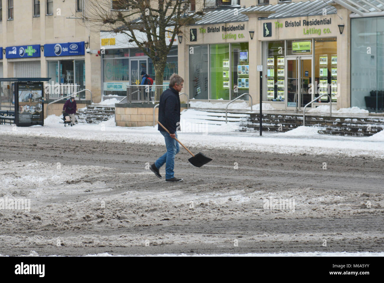 Bristol, UK. 2nd Mar, 2018. UK Weather.Storm Emma.passer by lends a helping hand clearing snow ,Whiteladies Road,Bristol. Credit: Robert Timoney/Alamy Live News Stock Photo