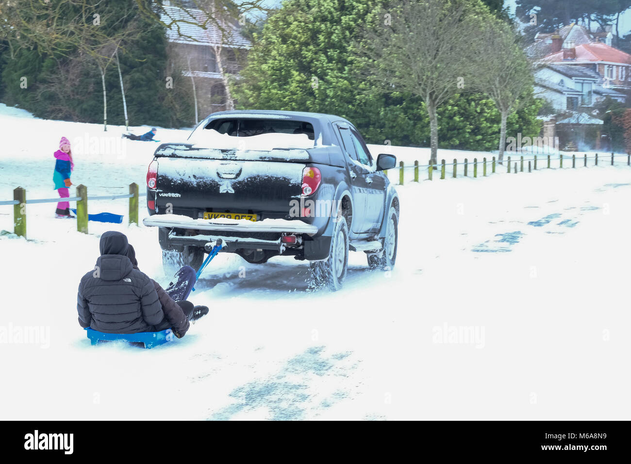 Portishead, Somerset, UK. 2nd March, 2018. UK Weather, Portishead, N. Somerset, UK  Storm Emma left deep snow drifts and icy conditions across the west country today. More snow is forecast for later this afternoon and a Yellow warning for more snow is in place. these two lads take advantgae of the conditions for some fun in the snow, getting a tow behind a 4x4 vehicle Credit: Stephen Hyde/Alamy Live News Stock Photo