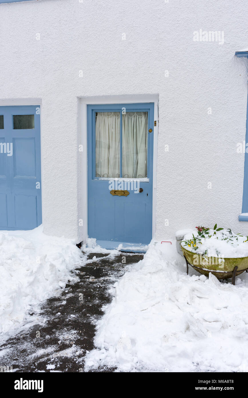Snow cleared from the front door of a cottage in the village of ...