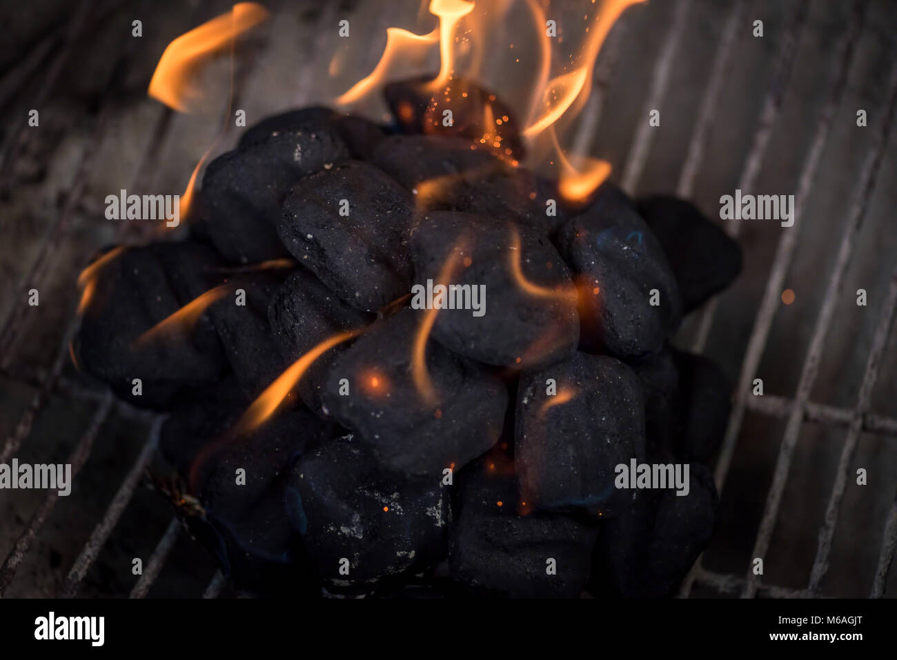 macro closeup of charcoals on grill with flames rising up Stock Photo