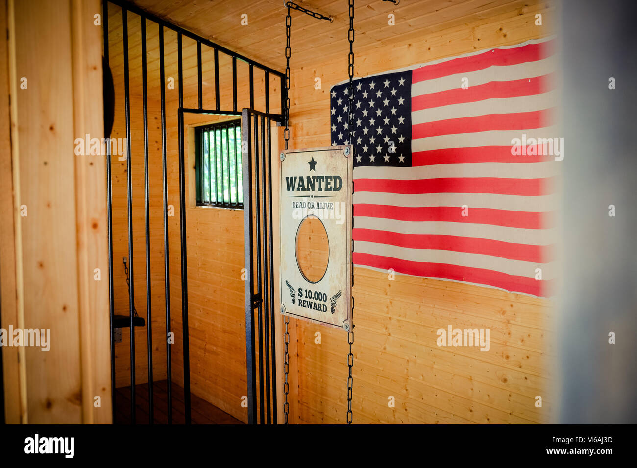 Wild West jail door and wanted sign with american flag in the background Stock Photo