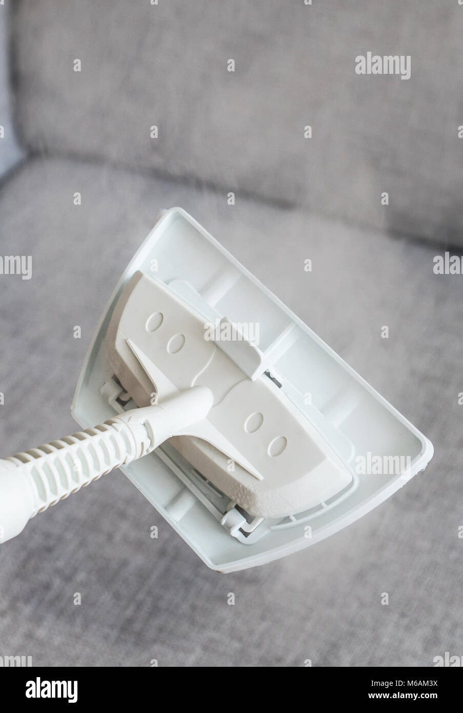 Cleaning fabric of the sofa with a steam cleaner Stock Photo Alamy