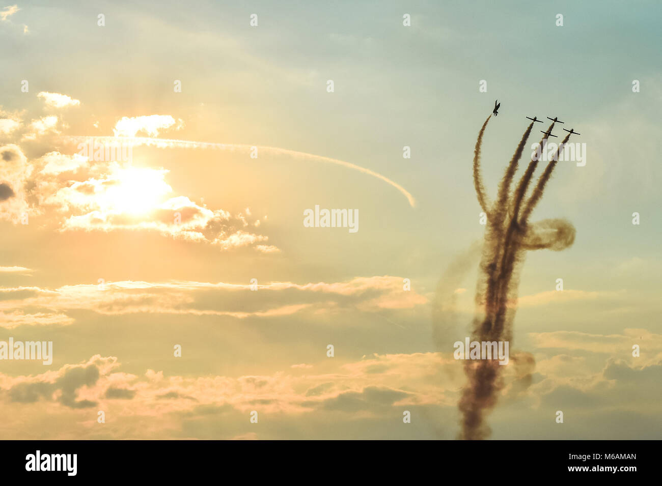 Acrobatic planes doing acrobatics at an Airshow flying at sunset / dusk Stock Photo