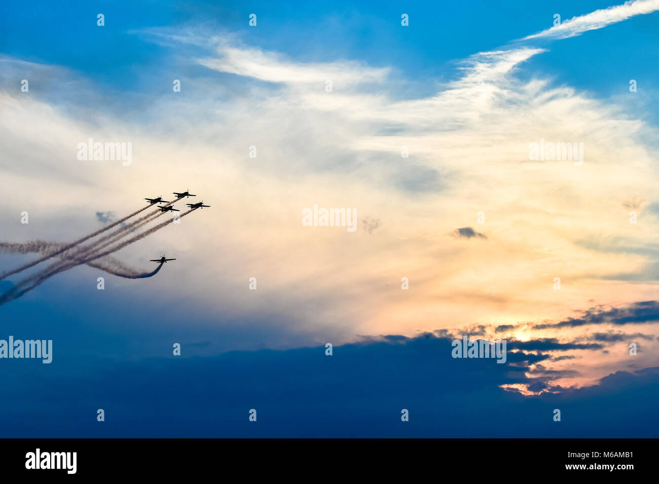 Acrobatic planes in action at an Airshow flying at sunset / dusk Stock Photo