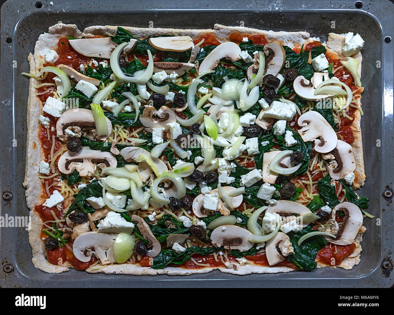 Vegetarian pizza on a baking tray before baking, Germany Stock Photo