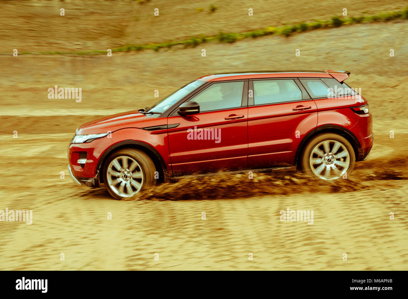 Range Rover Evoque driving fast off road in sand turning quickly with