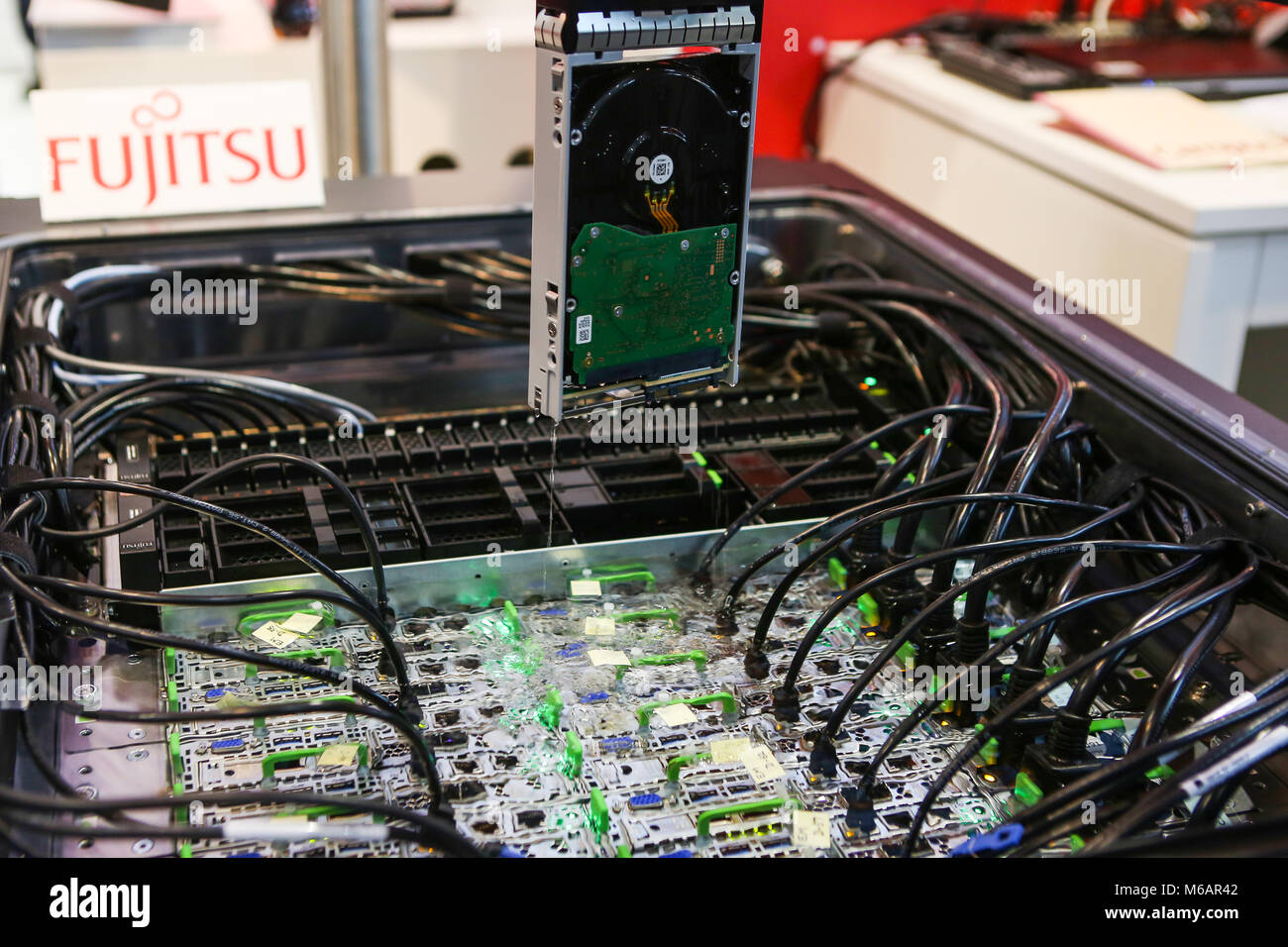 Hanover, Germany. 19th March, 2017. CeBIT 2017, ICT trade fair: Fujitsu Liquid Immersion Cooling System for data center servers, at booth of Fujitsu. Immersing servers in a fluorocarbon-based inert fluid (here 3M Fluorinert) provides greater cooling performance, eliminates the need for server fans and reduces total cooling equipment power consumption. Credit: Christian Lademann Stock Photo