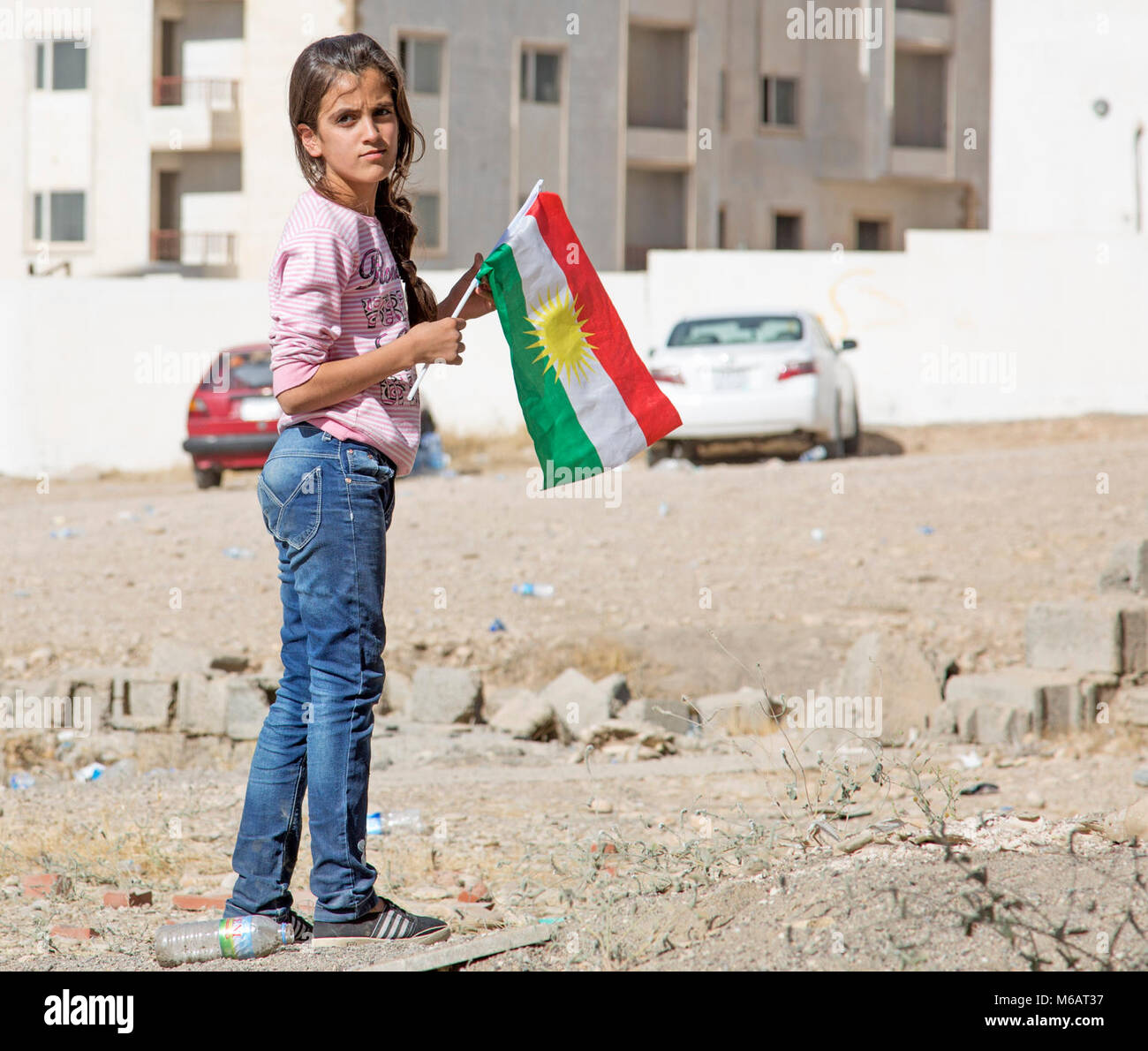 A young Kurdish girl holds a flag in a make-shift internally displaced person camp at the Kurdistan Training Coordination Center near Erbil, Iraq, October 19, 2017. (U.S. Army Stock Photo