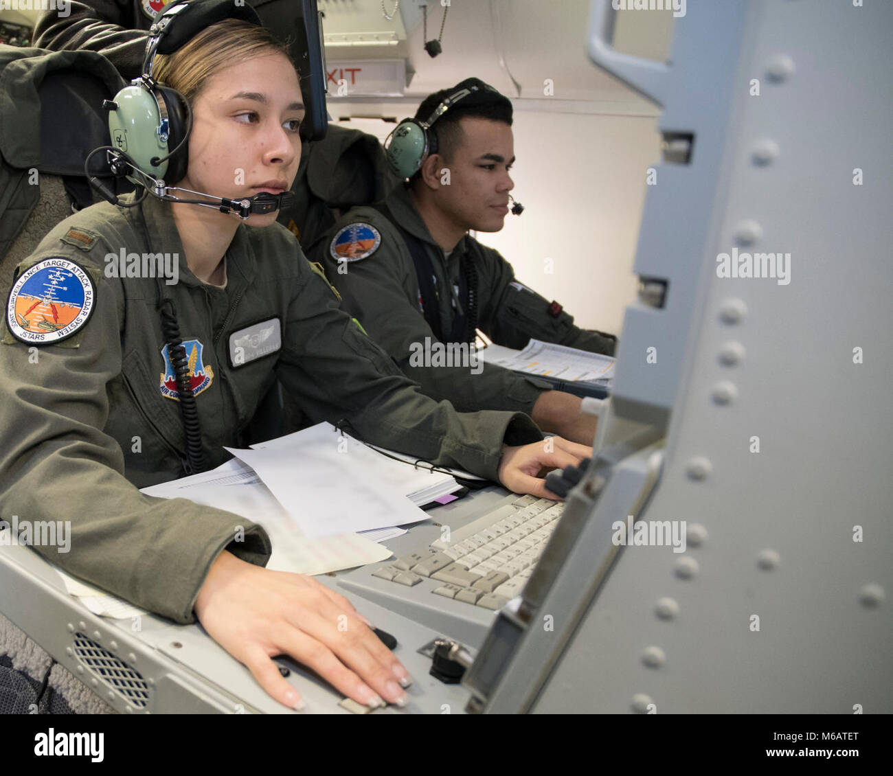 U.S. Air Force 2nd Lt. Amanda Villegas, left, and 1st Lt. Aryk Bingham-Hill, air weapons officers with the 330th Combat Training Squadron, perform a pre-flight inspection at their operator work stations aboard an E-8C Joint STARS during Exercise Razor Blade 18-02 at Robins Air Force Base, Ga., Feb. 8, 2018. The exercise was a readiness assessment meant to evaluate and measure Team JSTARS ability to rapidly deploy and employ combat ready Airmen and airpower. The focus of the exercise revolved around processing people, cargo, and the E-8C Joint STARS. Team JSTARS, consisting of the Georgia Air N Stock Photo