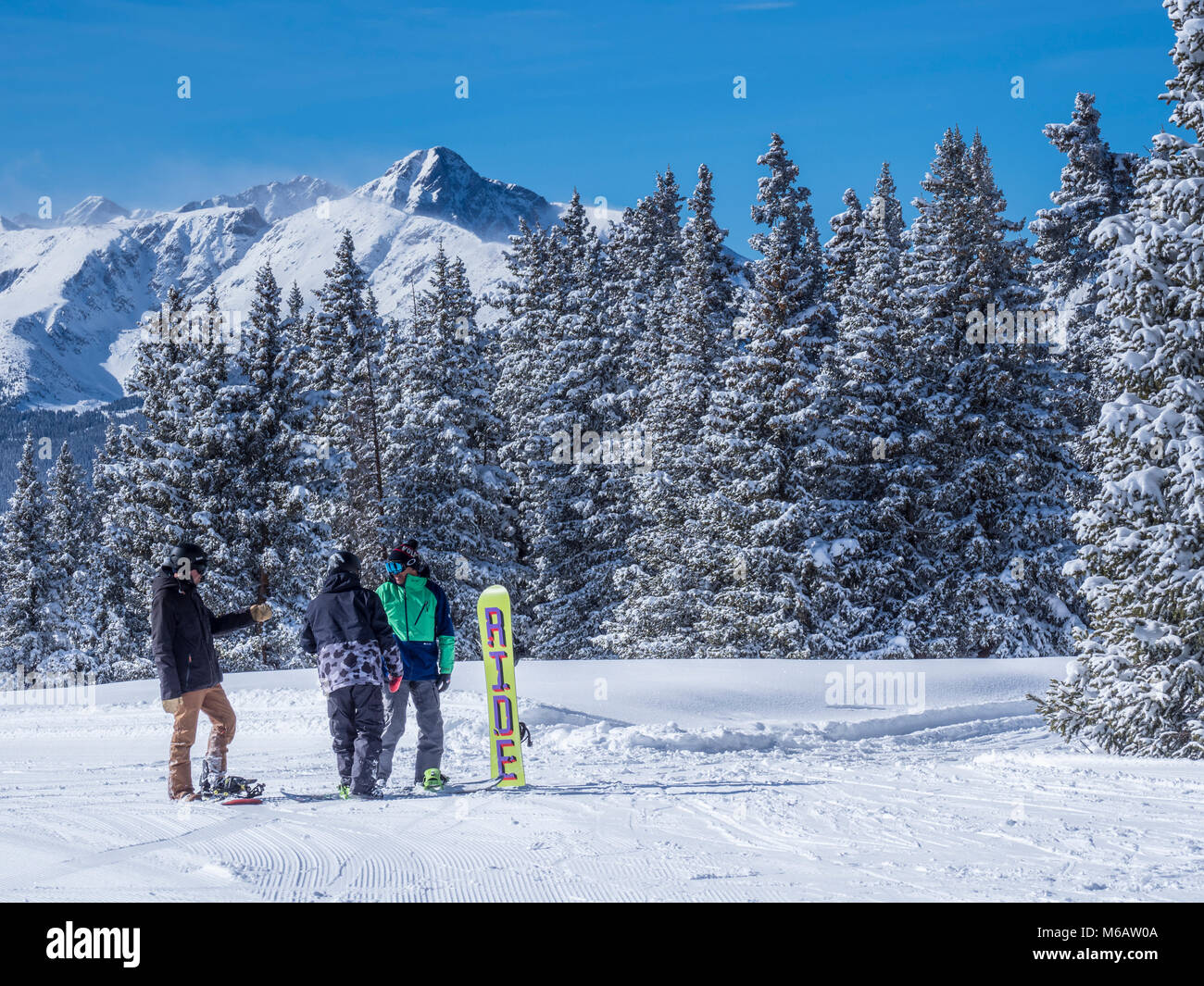 Snowboarders with Mount of the Holy Cross behind them, Belle's Camp, Blue Sky Basin, winter, Vail Ski Resort, Vail, Colorado. Stock Photo