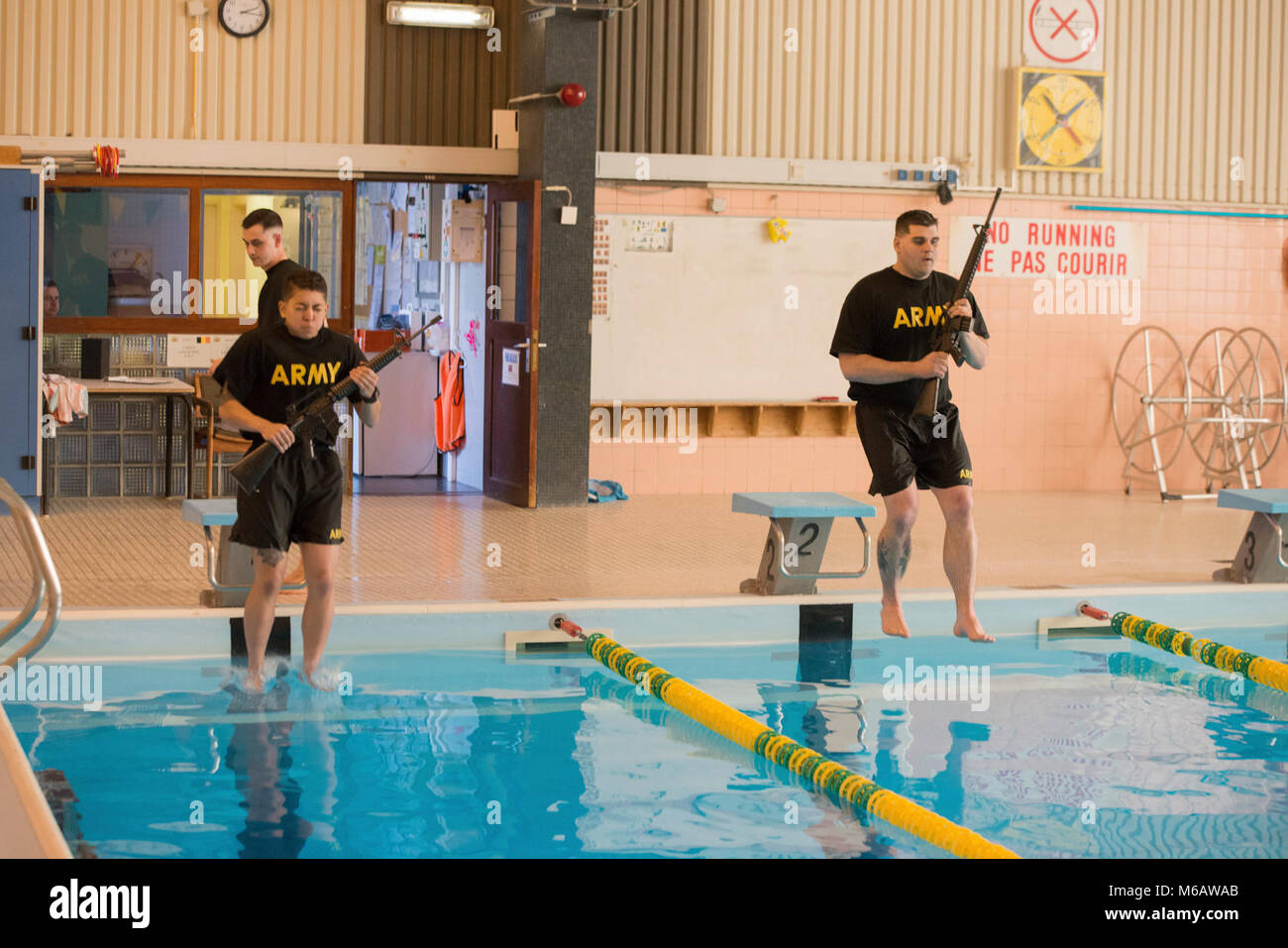 U.S. Army Spc. Jacqueline Delgado (left), assigned to the Chièvres Military Police at U.S. Army Garrison Benelux, and Spc. Jesse Watkins (right), assigned to the Schinnen Provost Marshal Office at USAG Benelux, compete for the garrison’s Best Warrior Competition in the swimming pool at the Supreme Headquarters Allied Powers Europe, Belgium, Feb. 21, 2018. (U.S. Army Stock Photo