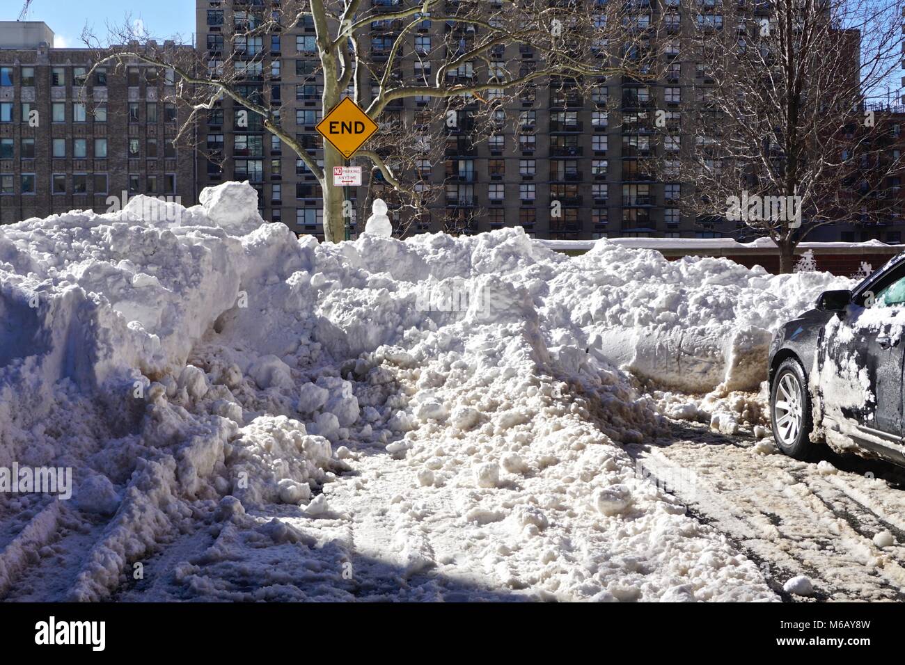 Midtown Manhattan, New York City: “END” and “No Parking Anytime” signs with a pile of snow that was plowed into a cul-de-sac after a blizzard. Stock Photo