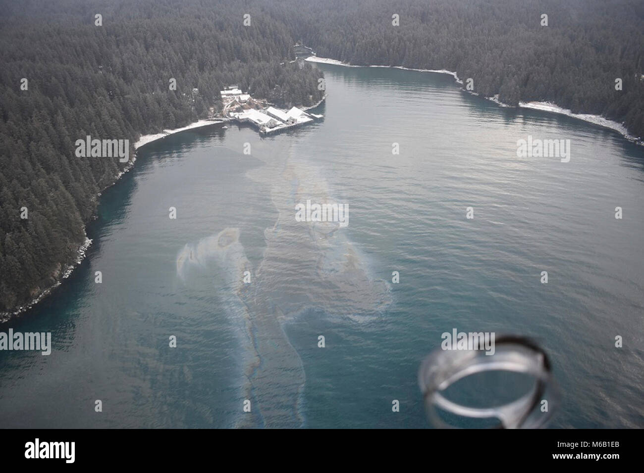 A Coast Guard Air Station Kodiak MH-60 helicopter crew and Marine Safety Detachment Kodiak pollution responders conduct an overflight in response to an oil spill in Shuyak Strait, 49 miles north of Kodiak, Alaska, Feb. 27, 2018. The Coast Guard and Alaska Department of Environmental Conservation established a unified command in response to the oil spill. U.S. Coast Guard Stock Photo