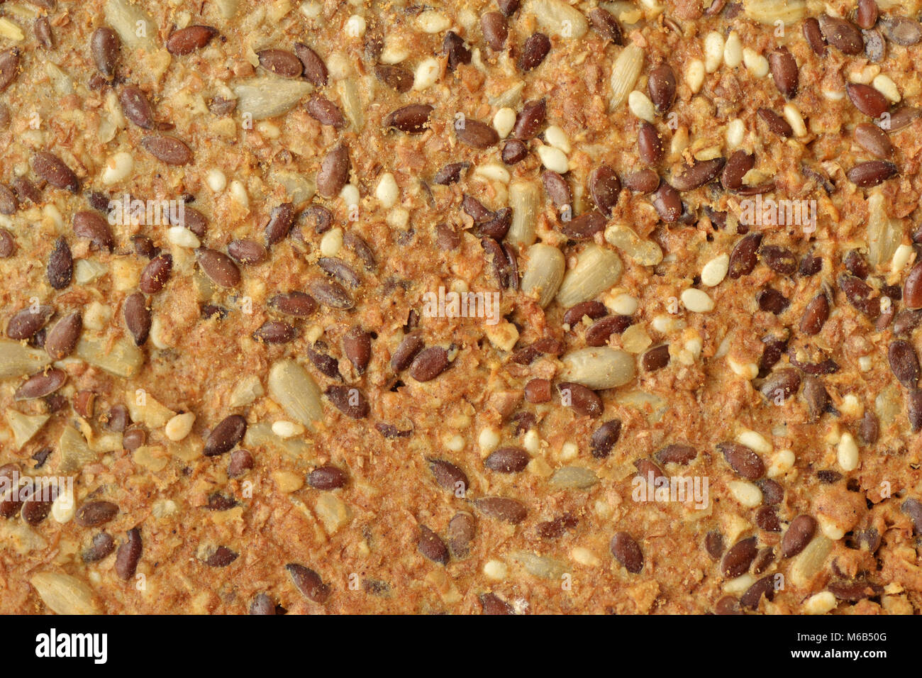 Texture background of crispy flatbread cracker with flax, sunflower and