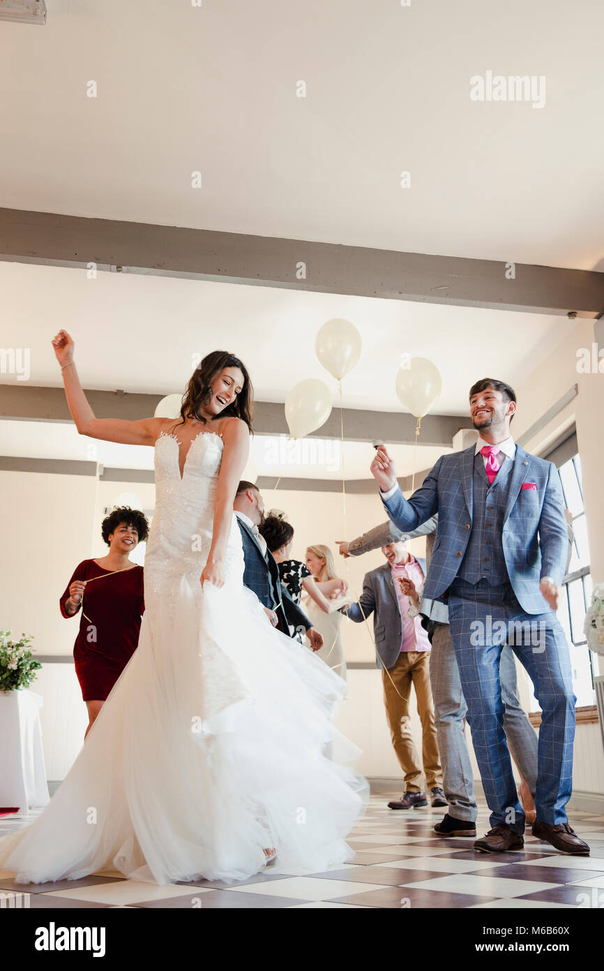 Newly wed couple are enjoying dancing with all of their guests on their wedding day. Stock Photo