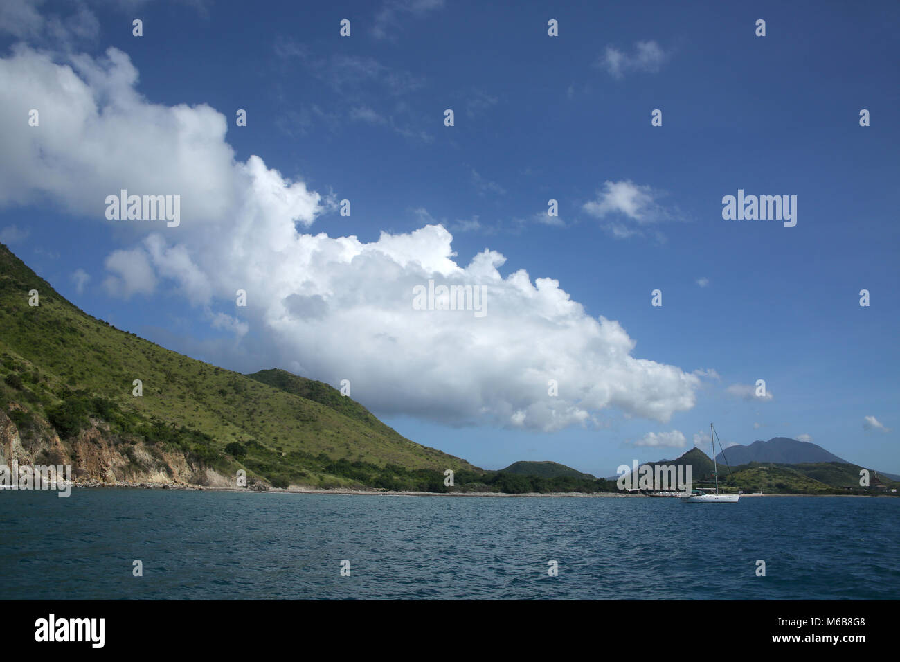 View of the coastline from the sea with a sailing boat, St Kitts, Caribbean. Stock Photo