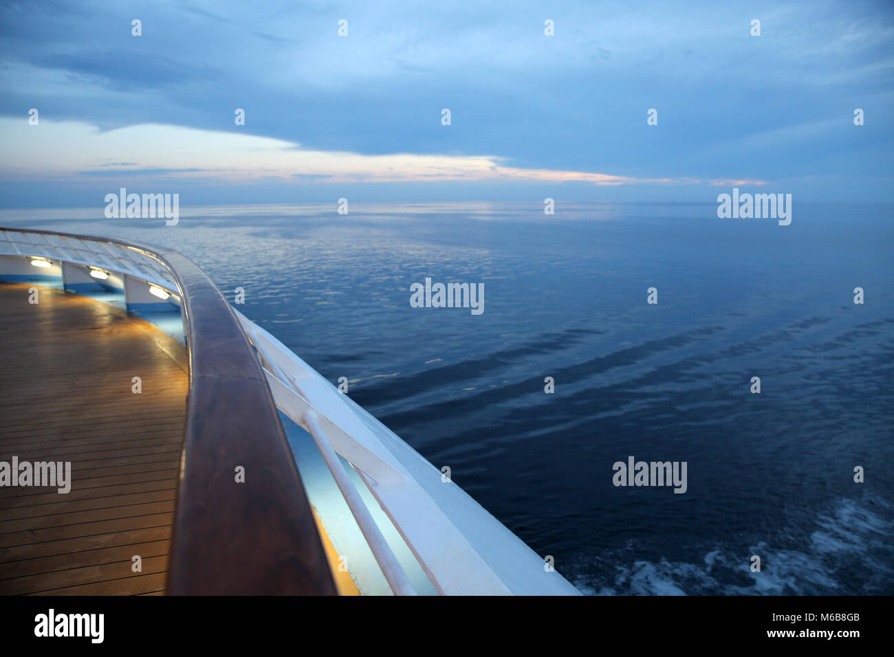 Twlight over a cruise ship deck, sailing across the calm ocean. Stock Photo