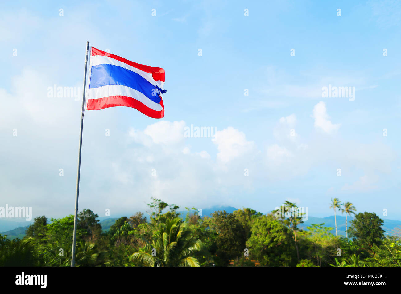flag of Thailand against the sky and mountains, blue white and red ...