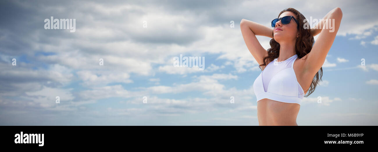 Composite image of young woman in bikini against white background Stock Photo