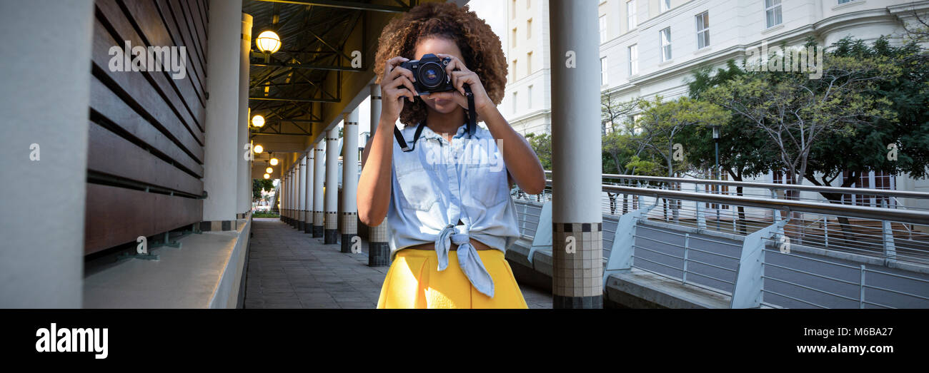 Composite image of young woman holding camera Stock Photo - Alamy
