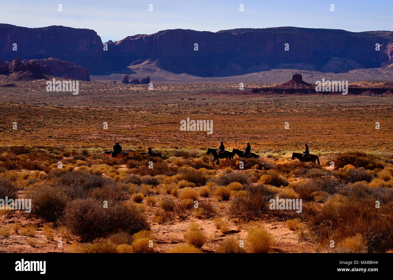 Group of horse riders in Monument Valley, Utah, United States of America Stock Photo