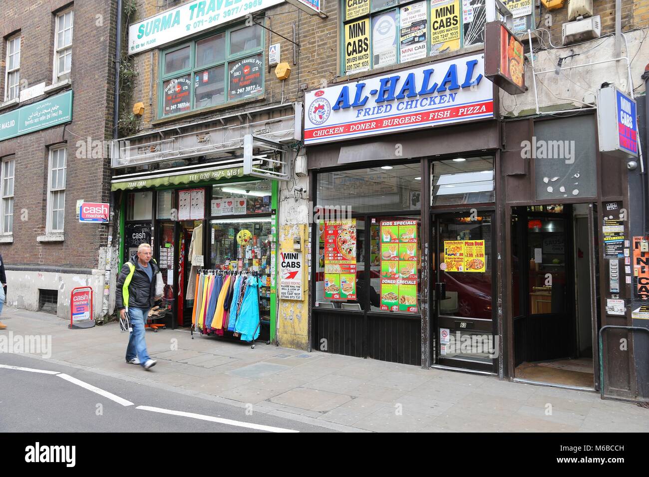 LONDON, UK - APRIL 22, 2016: People walk by ethnic stores and restaurants at Brick Lane, Shoreditch, London. Shoreditch is known for its multicultural Stock Photo