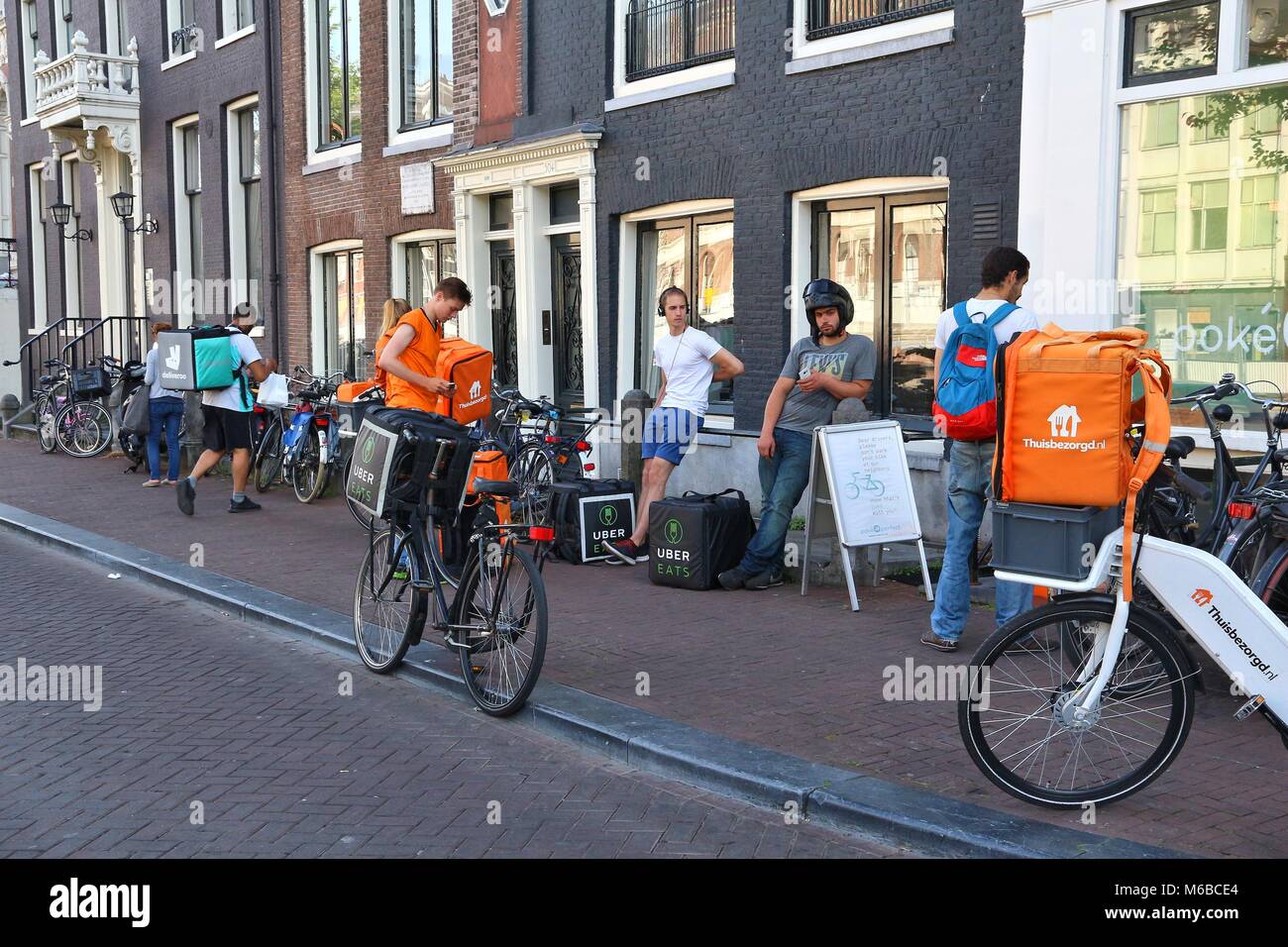 AMSTERDAM, NETHERLANDS - JULY 9, 2017: Uber Eats, Thuisbezorgd and  Deliveroo food couriers wait in Amsterdam, Netherlands. Bicycle food  delivery is po Stock Photo - Alamy