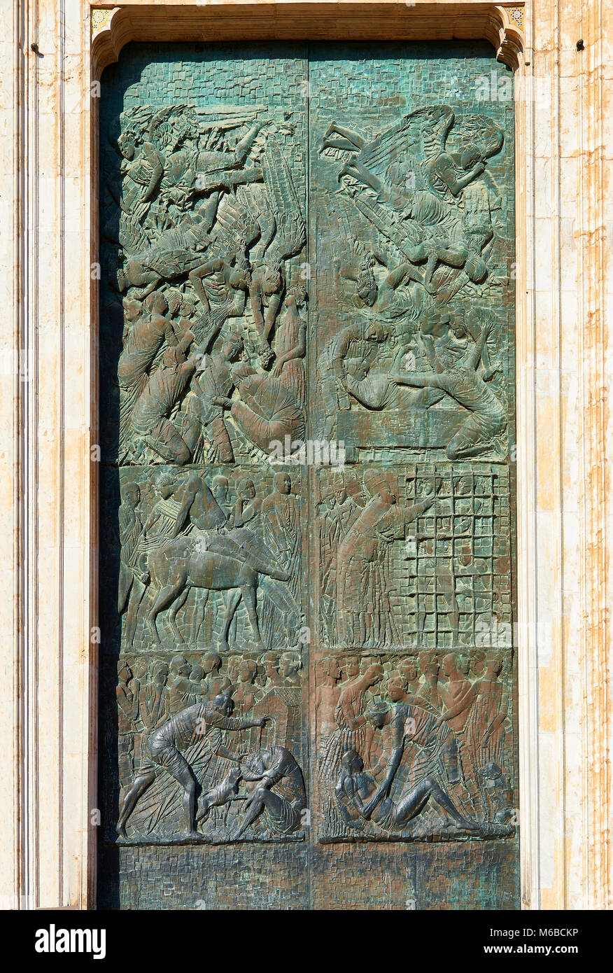 Close up of the main door sculptures made in 1970 by the Sicilian sculptor Emilio Greco (1913–1995) depicting mercies from the life of Christ, 14th ce Stock Photo
