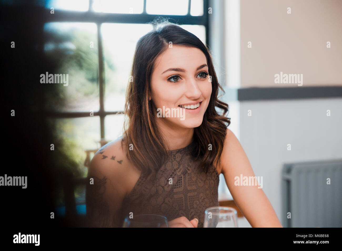 Young women is enjoying herself at a social event with friends. They are drinking wine. Stock Photo