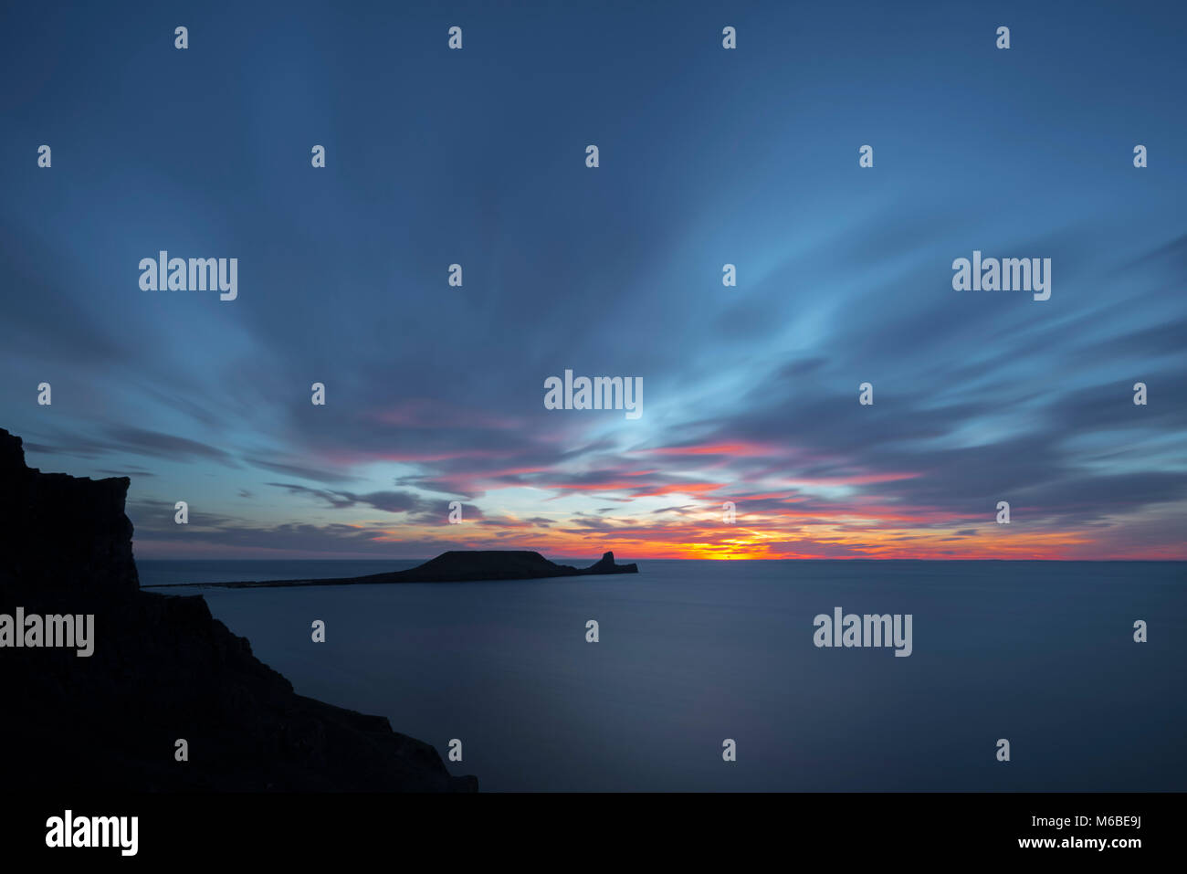 Sunset over Worm's Head, Rhossili Bay, Gower, Wales, U.K Stock Photo
