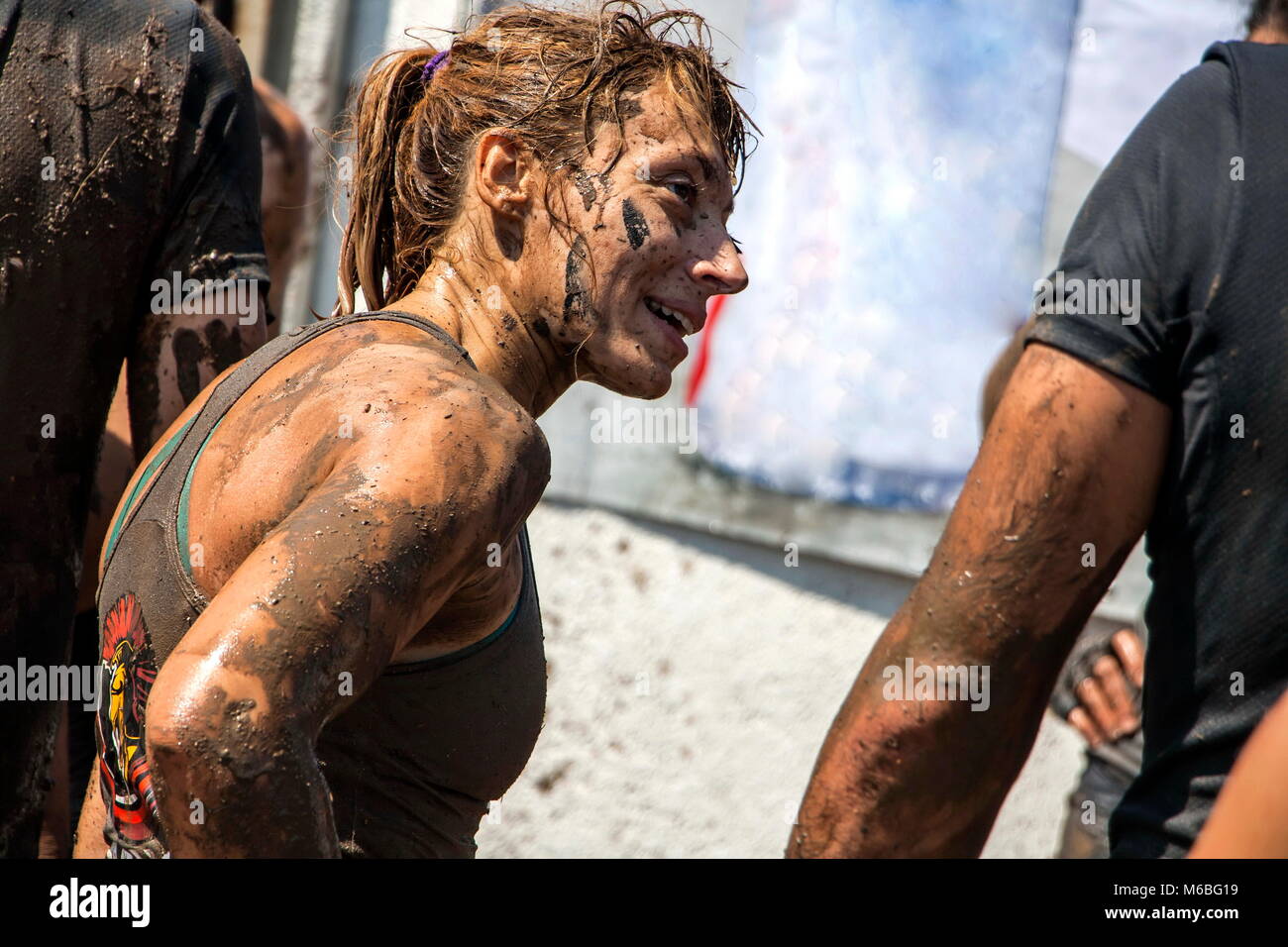 Young woman is smiling after overcoming the last challenge in an open sport challenge; concept of courage, determination and success Stock Photo