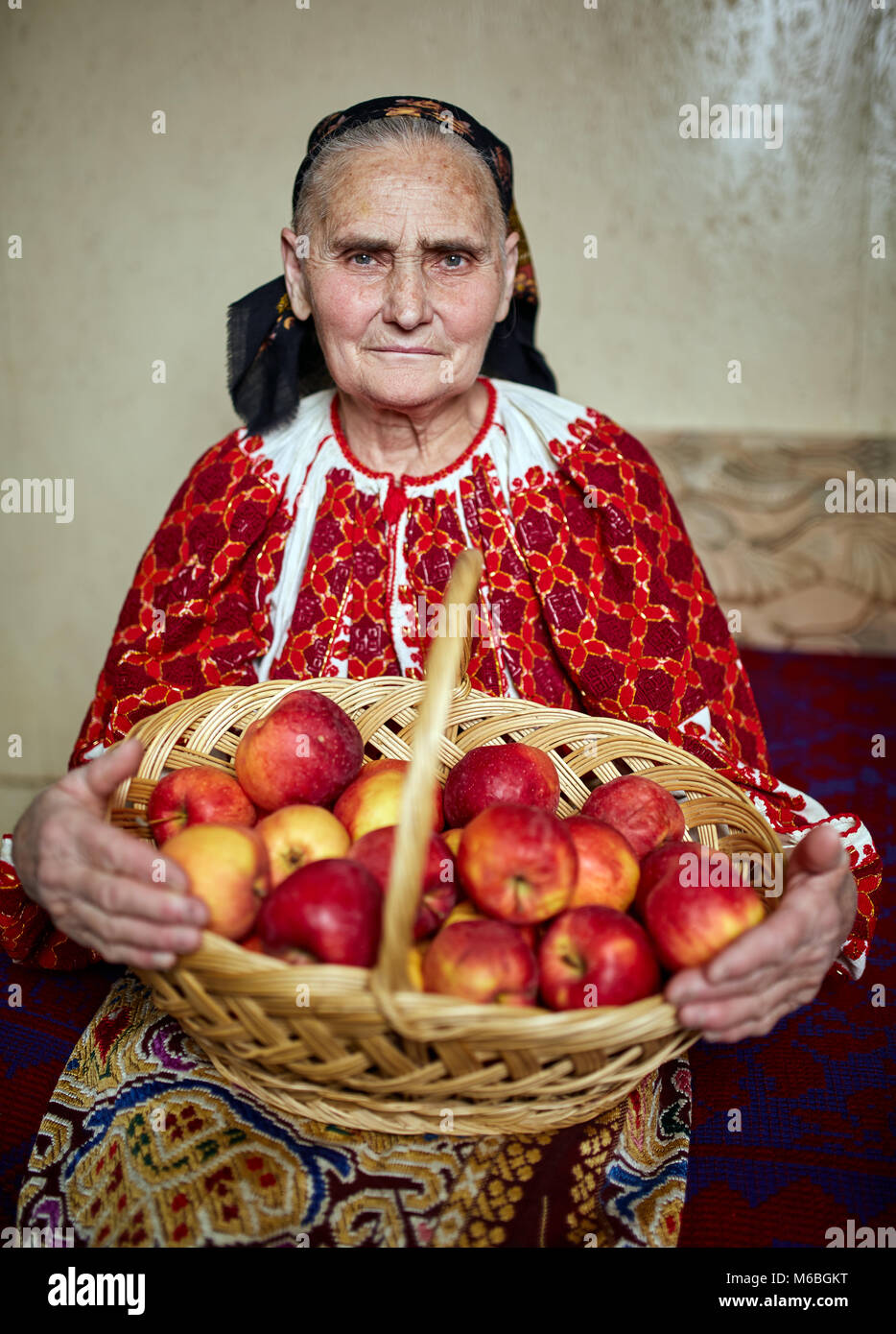 Old farmer woman in traditional costume holding a basket full of apples  Stock Photo - Alamy
