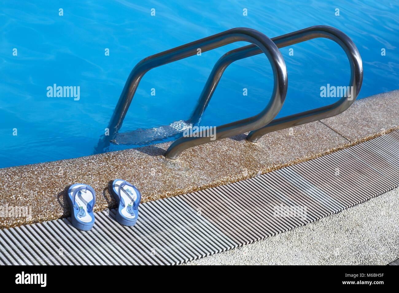 Flip-flops and sunglasses by swimming pool Stock Photo - Alamy