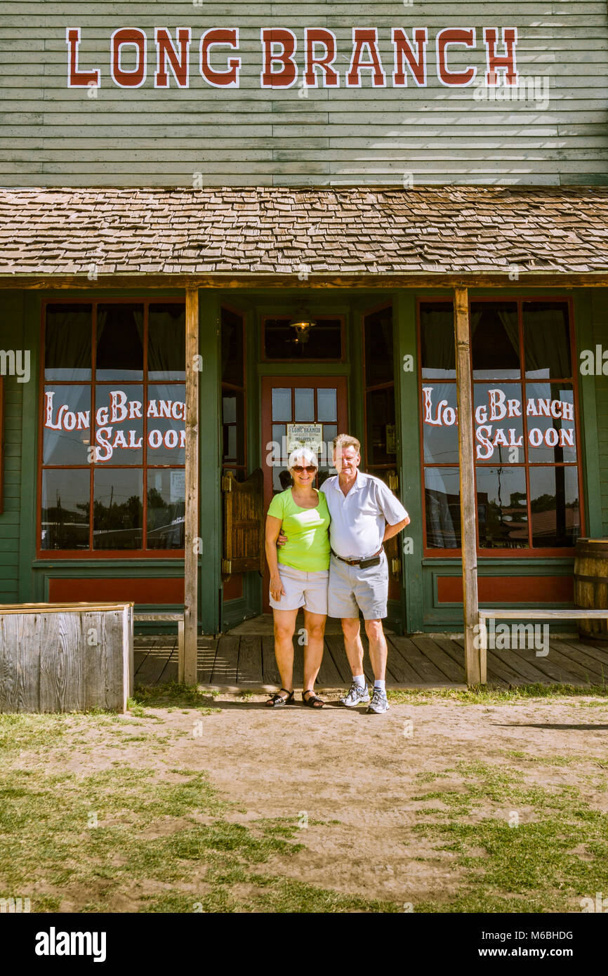 Couple outside Long Branch saloon in Dodge City, Kansas. Building