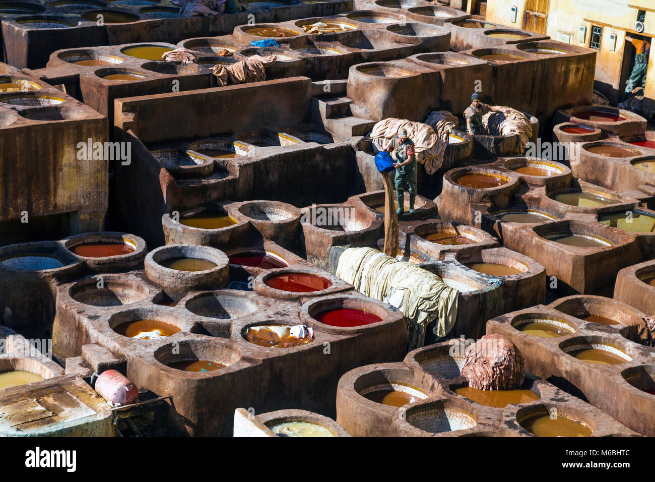 Craftsmen dyeing leather at Chaouwara tanneries in Fez, Morocco Stock Photo