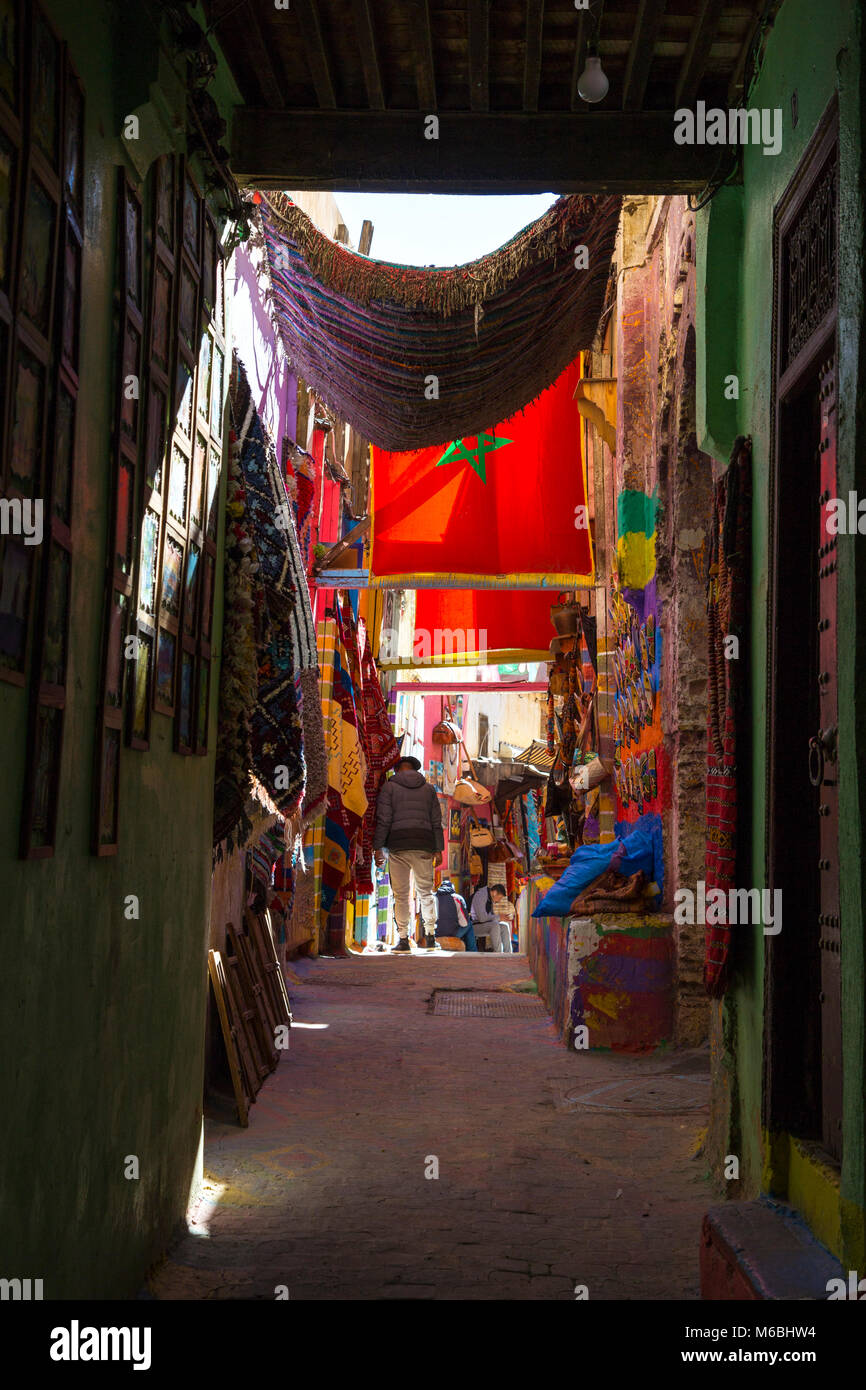 Street in the souks with stalls, shops and rugs hanging in the old medina in Fes, Morocco Stock Photo