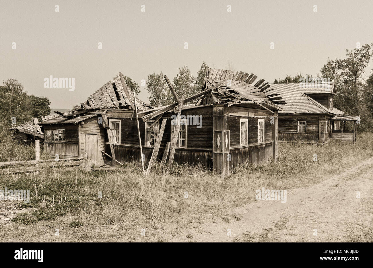 Retro photo with old wooden broken houses in russian abandoned village