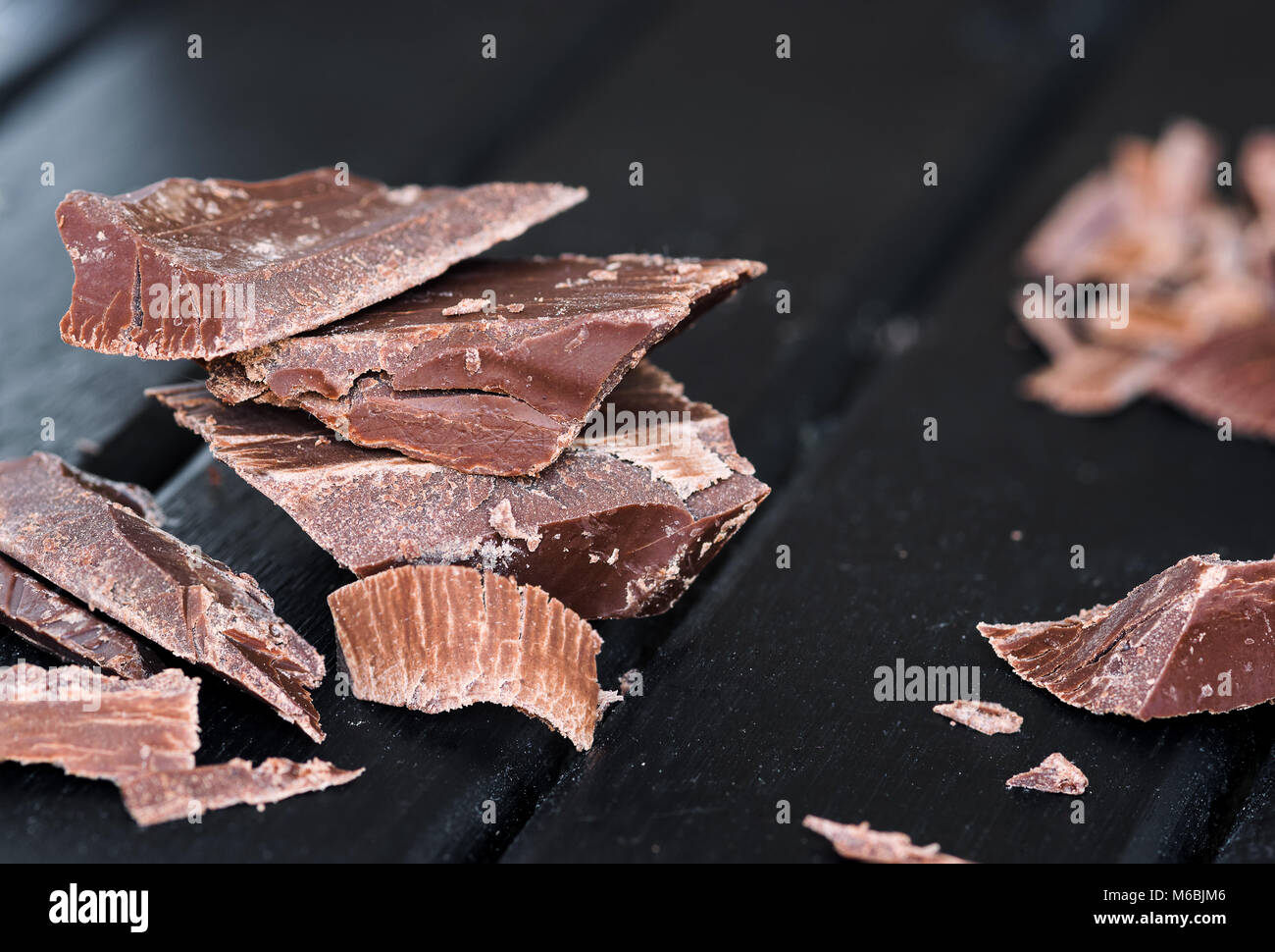Delicious Chocolate pieces on a dark wooden moody background, closeup macro, with lots of texture Stock Photo