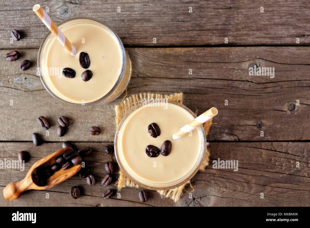 Coffee, banana smoothie in two glasses. Top view, corner orientation over a rustic wood background, Stock Photo