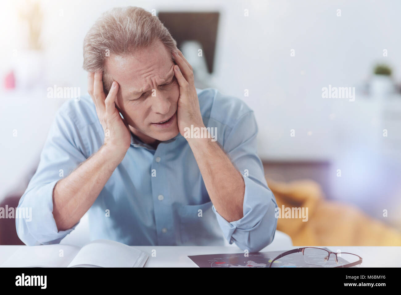 Tired cheerless man suffering from the headache Stock Photo