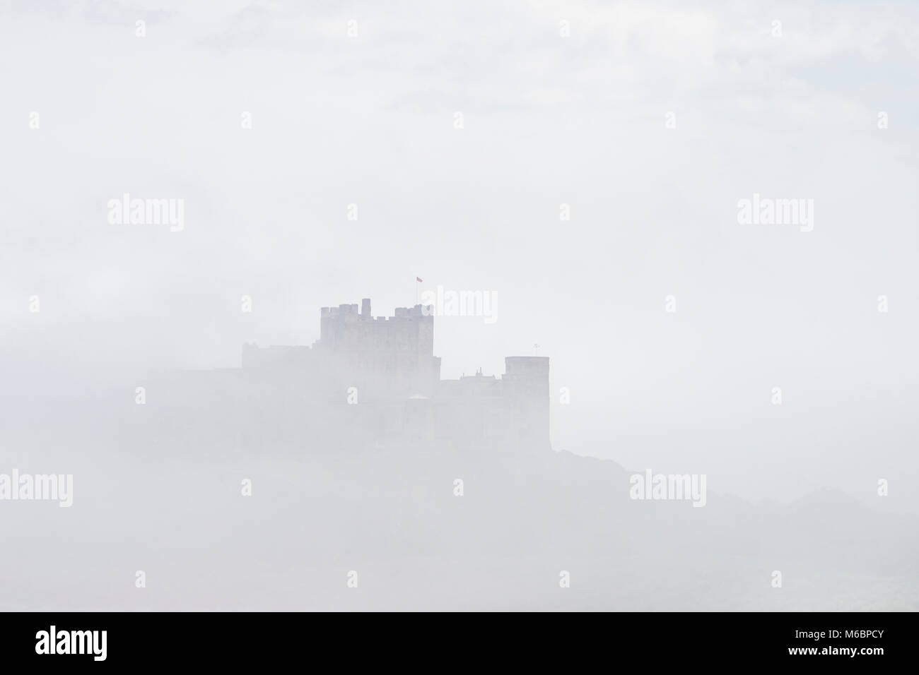 Bamburgh Castle emerging from a sea fret, Northumberland, England Stock Photo