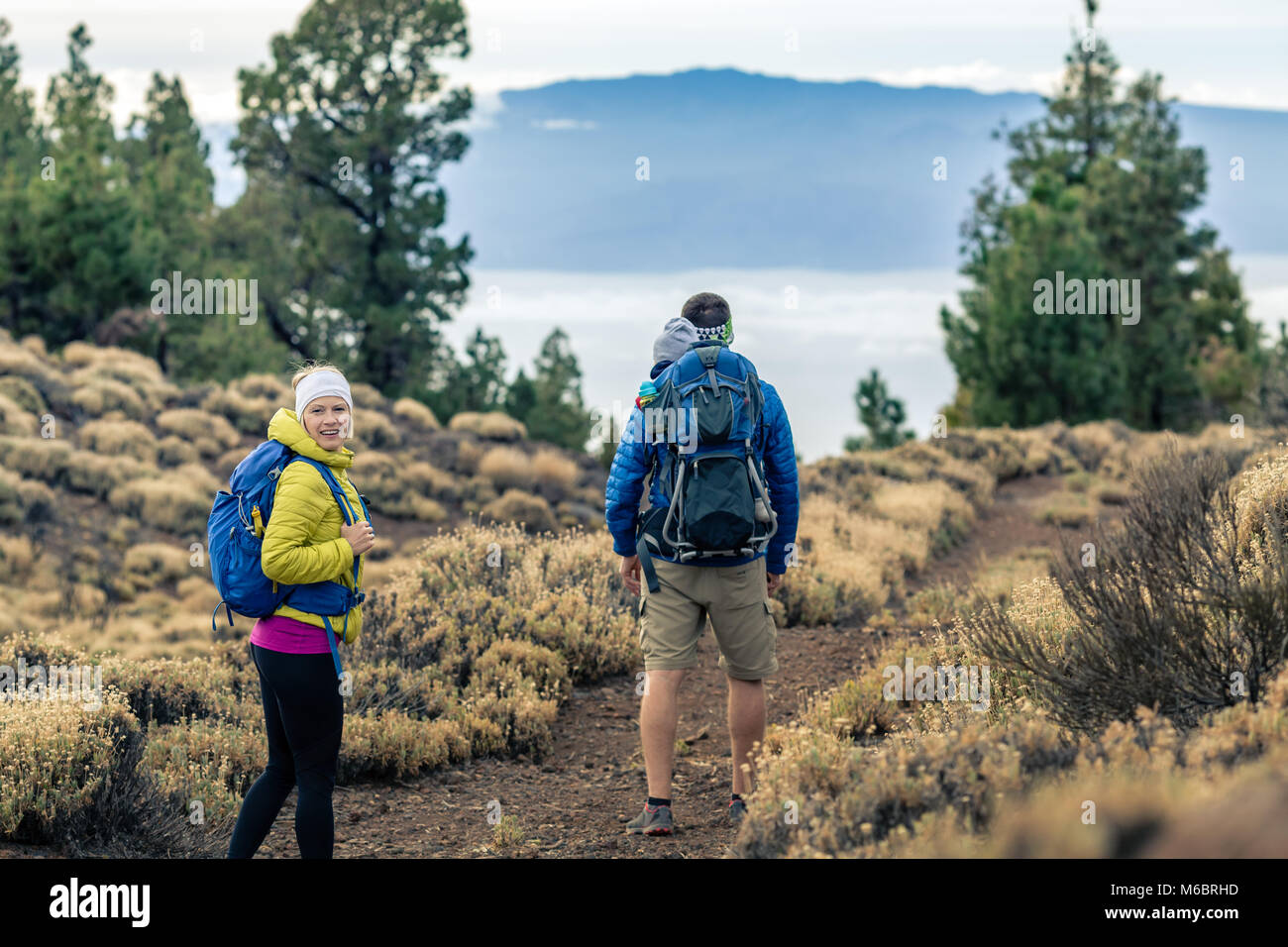 Couple hiking with baby boy travelling in backpack. Hikers family, adventure with child on
