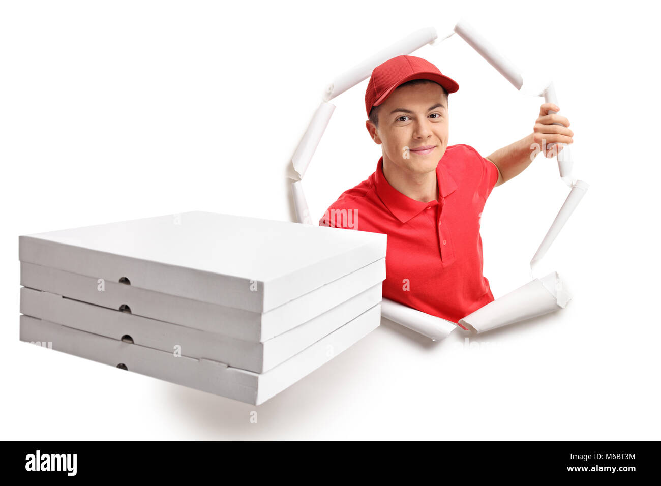 Teen delivery boy with pizza boxes breaking through paper Stock Photo