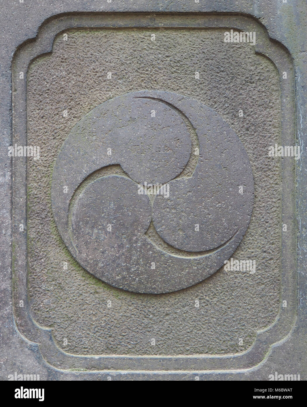 Ancient stone Japanese Shinto religion trinity symbol carving. Stock Photo
