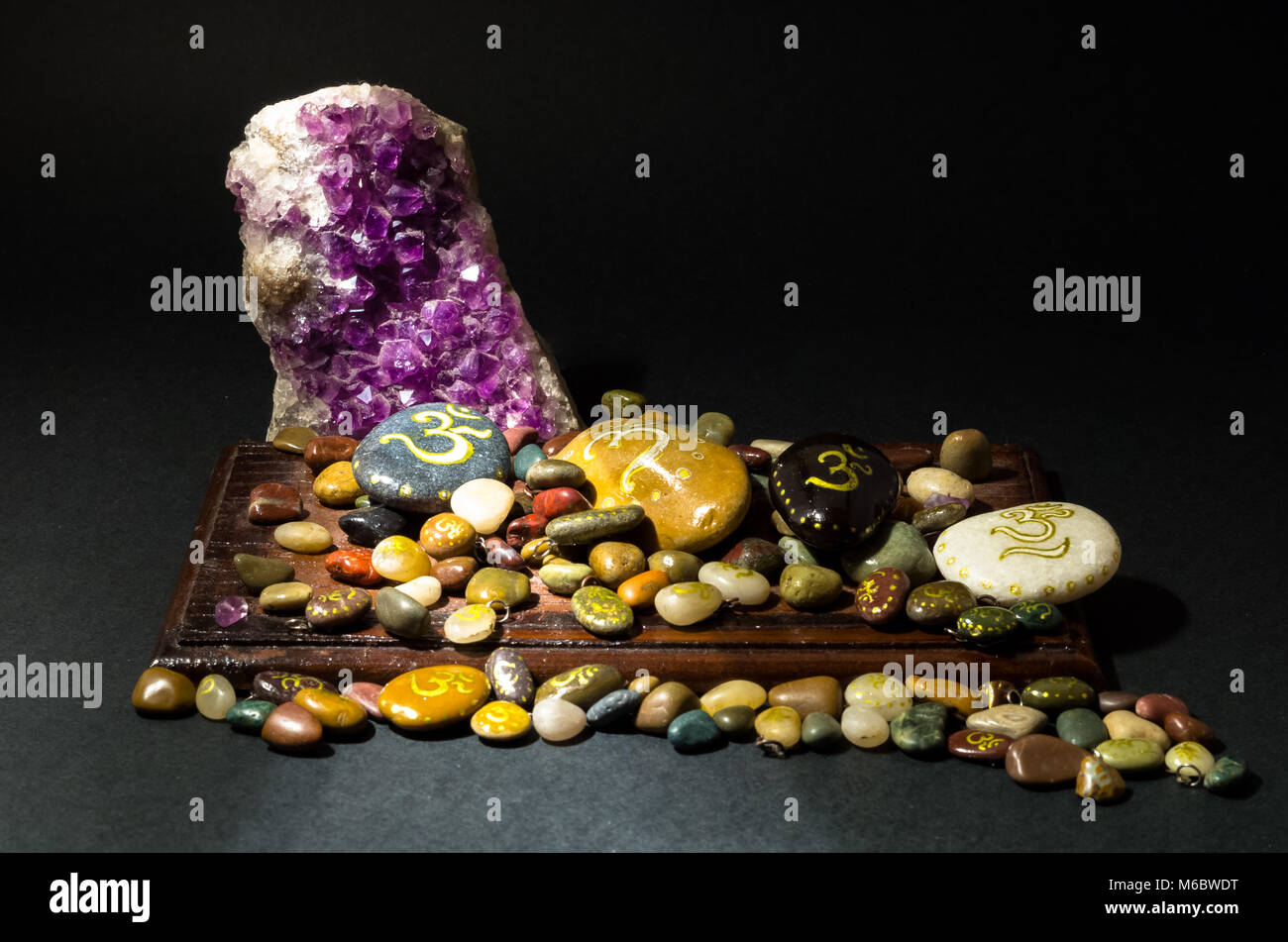 Amethyst crystal and painted stones with Om symbol Stock Photo