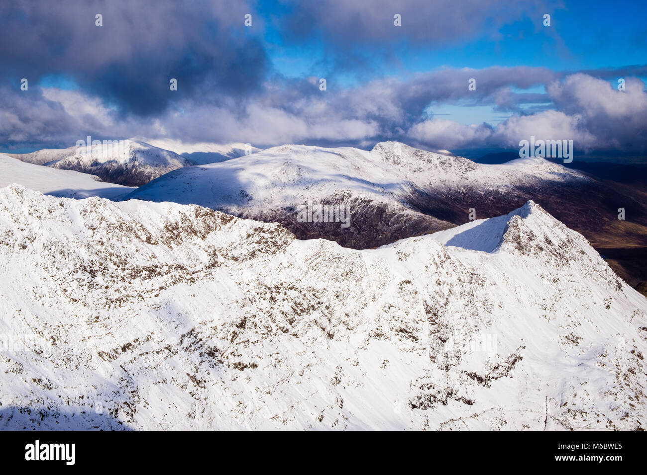 View to Crib Goch ridge and Crib Y Ddysgl in Snowdon horseshoe from Snowdon summit with Glyderau beyond in winter snow in Snowdonia Wales UK Stock Photo