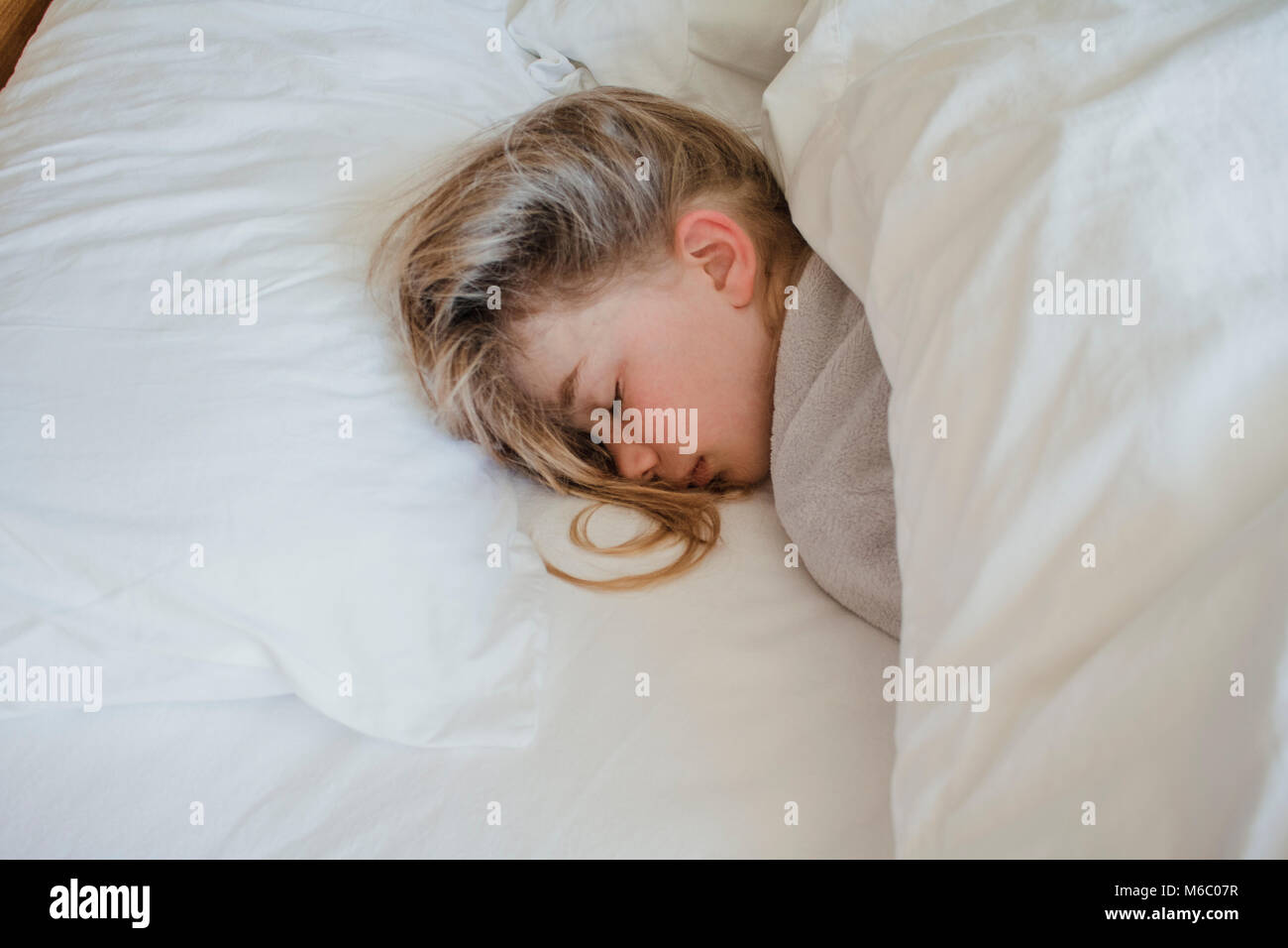 Little girl is fast asleep in bed. Stock Photo